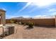 Landscaped backyard with gravel, grass, and a block wall at 8297 W Rushmore Way, Florence, AZ 85132