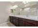 Double vanity bathroom with dark wood cabinets and a shower at 8297 W Rushmore Way, Florence, AZ 85132