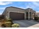 One-story house with brown garage door and landscaped yard at 8297 W Rushmore Way, Florence, AZ 85132