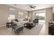 Bright living room featuring neutral tones, a ceiling fan, and sliding glass doors to the patio at 8297 W Rushmore Way, Florence, AZ 85132