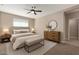 Serene main bedroom with a ceiling fan, neutral decor, and a dresser with round mirror at 8297 W Rushmore Way, Florence, AZ 85132