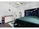 Well-lit bedroom with a dark-blue headboard and green bedding at 9625 E Spiral Ave, Mesa, AZ 85212