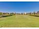 Irrigated grassy lawn with homes in the background at 9625 E Spiral Ave, Mesa, AZ 85212