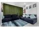 Living area with dark blue sectional sofa, green accent wall, and patterned rug at 9625 E Spiral Ave, Mesa, AZ 85212