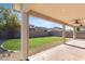 Covered patio overlooks a grassy backyard with a shaped lawn and rock border at 11625 W Jackson St, Avondale, AZ 85323