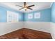 Bright bedroom with hardwood floors, ceiling fan, and window shutters at 11625 W Jackson St, Avondale, AZ 85323