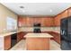 Kitchen boasts wood cabinets, island, and black appliances at 11625 W Jackson St, Avondale, AZ 85323