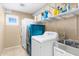 Laundry room with washer, dryer, shelving, and utility sink at 11625 W Jackson St, Avondale, AZ 85323