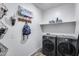 Laundry room with washer, dryer, and storage shelves at 14355 W Desert Hollow Dr, Surprise, AZ 85387