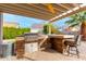 Outdoor kitchen with built-in grill, stone countertops, and a covered patio at 1451 E Ivanhoe St, Gilbert, AZ 85295