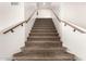 Indoor staircase with carpeted steps and wood railings at 1451 E Ivanhoe St, Gilbert, AZ 85295