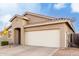 One story house with tan exterior, two-car garage, and desert landscaping at 15207 W Windward Ave, Goodyear, AZ 85395