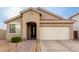 One-story house with tan exterior, two-car garage, and landscaped front yard at 15207 W Windward Ave, Goodyear, AZ 85395