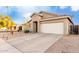 One-story house with tan exterior, two-car garage, and driveway at 15207 W Windward Ave, Goodyear, AZ 85395