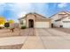 Tan one-story house with a two-car garage and front walkway at 15207 W Windward Ave, Goodyear, AZ 85395