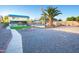 View of backyard featuring a fire pit, gravel, palm trees, and a view of the home at 15727 W Rimrock St, Surprise, AZ 85374