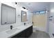 Bathroom featuring double sinks, black hardware, and shower/tub combo at 15727 W Rimrock St, Surprise, AZ 85374