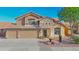 Charming two-story home featuring a three-car garage, stone accents, and landscaped front yard at 15727 W Rimrock St, Surprise, AZ 85374