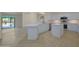 White kitchen with tile floor, island, stainless steel appliances and sliding glass doors to patio at 15727 W Rimrock St, Surprise, AZ 85374