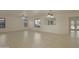 Large, open living room with tile flooring, fan, and neutral walls, adjacent to the kitchen at 15727 W Rimrock St, Surprise, AZ 85374