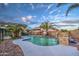 Stunning pool area with waterfall, palm trees, and a fenced backyard at 15727 W Rimrock St, Surprise, AZ 85374