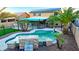 Backyard oasis featuring a sparkling pool, lush landscaping, and covered patio with solar panels at 15727 W Rimrock St, Surprise, AZ 85374