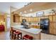 Modern kitchen with wood cabinets and black appliances at 17065 N Silver Path, Surprise, AZ 85374