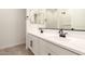 Modern bathroom with dual sinks, white cabinets, and sleek black hardware at 18219 W Hess St, Goodyear, AZ 85338