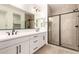 Bright bathroom features a double sink vanity with undermount sinks and a tiled shower with black trim at 18219 W Hess St, Goodyear, AZ 85338