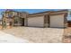 Two-car garage with driveway and stone accents around the house, providing curb appeal and ample parking at 18219 W Hess St, Goodyear, AZ 85338
