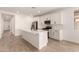 Open-concept kitchen with island featuring stainless appliances, white cabinets, and a stylish black faucet at 18219 W Hess St, Goodyear, AZ 85338
