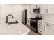 Modern kitchen with stainless steel appliances, white cabinets, subway tile backsplash, and quartz countertops at 18219 W Hess St, Goodyear, AZ 85338