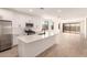 Bright, open kitchen and living area with stainless appliances, kitchen island, and sliding glass doors to the backyard at 18219 W Hess St, Goodyear, AZ 85338