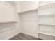 A simple walk-in closet features wood racks, shelves, and carpet flooring at 18219 W Hess St, Goodyear, AZ 85338