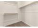 A simple walk-in closet features wood racks, shelves, and carpet flooring at 18219 W Hess St, Goodyear, AZ 85338