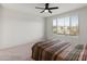 Bedroom with large window and ceiling fan at 18897 N 264Th Ln, Buckeye, AZ 85396