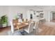 Modern dining area with wood table and white chairs, adjacent to kitchen at 18897 N 264Th Ln, Buckeye, AZ 85396