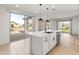 White kitchen island with sink, dishwasher, and breakfast bar at 18897 N 264Th Ln, Buckeye, AZ 85396