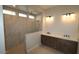 Modern bathroom with dual sinks, and a walk-in shower featuring decorative tile at 20233 W San Miguel Ave, Litchfield Park, AZ 85340