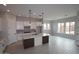 Bright and open kitchen with a large island, white cabinets, and a view into the living area at 20233 W San Miguel Ave, Litchfield Park, AZ 85340