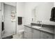 Modern bathroom with gray vanity, large mirror, and walk-in shower at 21312 N 113Th Pl, Scottsdale, AZ 85255