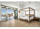 Main bedroom with a four-poster bed and access to a private patio with scenic views at 21312 N 113Th Pl, Scottsdale, AZ 85255