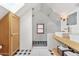 Attic bathroom features a shower, checkered tile floor, double sink, and natural light from a skylight and window at 2209 E Weldon Ave, Phoenix, AZ 85016