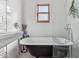 Well-lit bathroom with a black and white clawfoot tub and bright white tiles at 2209 E Weldon Ave, Phoenix, AZ 85016