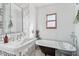 Bright bathroom with a classic clawfoot tub and modern geometric patterned mirror and tiles at 2209 E Weldon Ave, Phoenix, AZ 85016