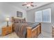 Bedroom with wooden bed frame and ceiling fan at 22992 W Lasso Ln, Buckeye, AZ 85326