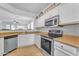 White kitchen with stainless steel appliances and granite countertops at 22992 W Lasso Ln, Buckeye, AZ 85326