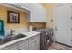 Functional laundry room with white cabinets, a utility sink, and a washer and dryer at 2310 W Hazelhurst Dr, Anthem, AZ 85086