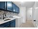 Bright laundry room with blue cabinets, patterned backsplash, and modern washer/dryer at 2425 W Bronco Butte Trl # 1032, Phoenix, AZ 85085