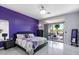 Main bedroom with a king-size bed, purple accent wall, and sliding glass doors leading to the patio at 26846 N 73Rd St, Scottsdale, AZ 85266